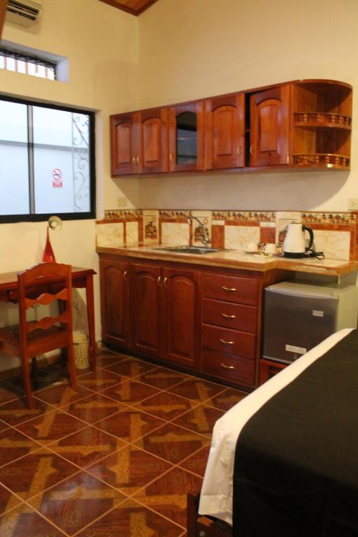 a kitchen with wooden cabinets and a table and a chair at Epoca Iquitos in Iquitos