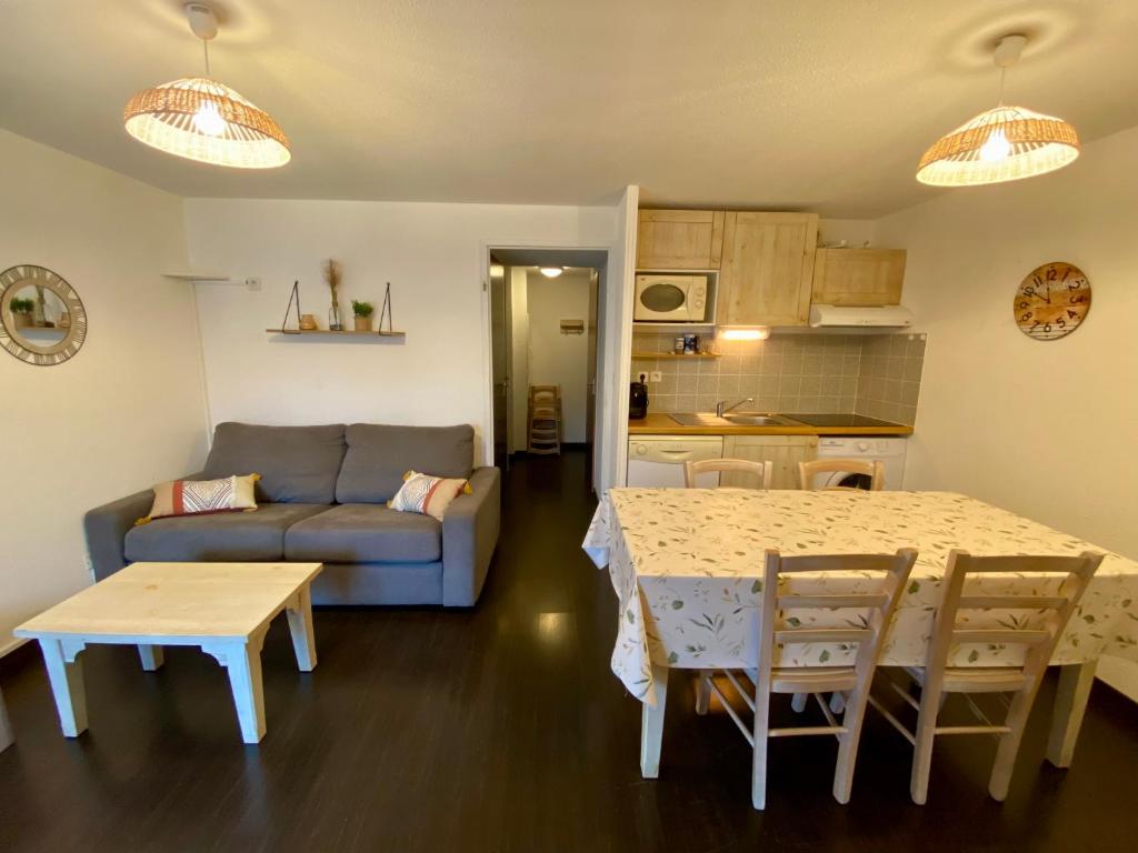 un salon avec une table et un canapé dans l'établissement Appartement RDC - Luz-St-Sauveur, à Luz-Saint-Sauveur