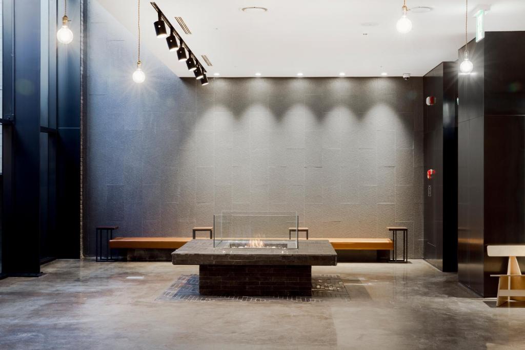 a table in a room with benches and a wall at Handpicked Hotel & Collections in Seoul