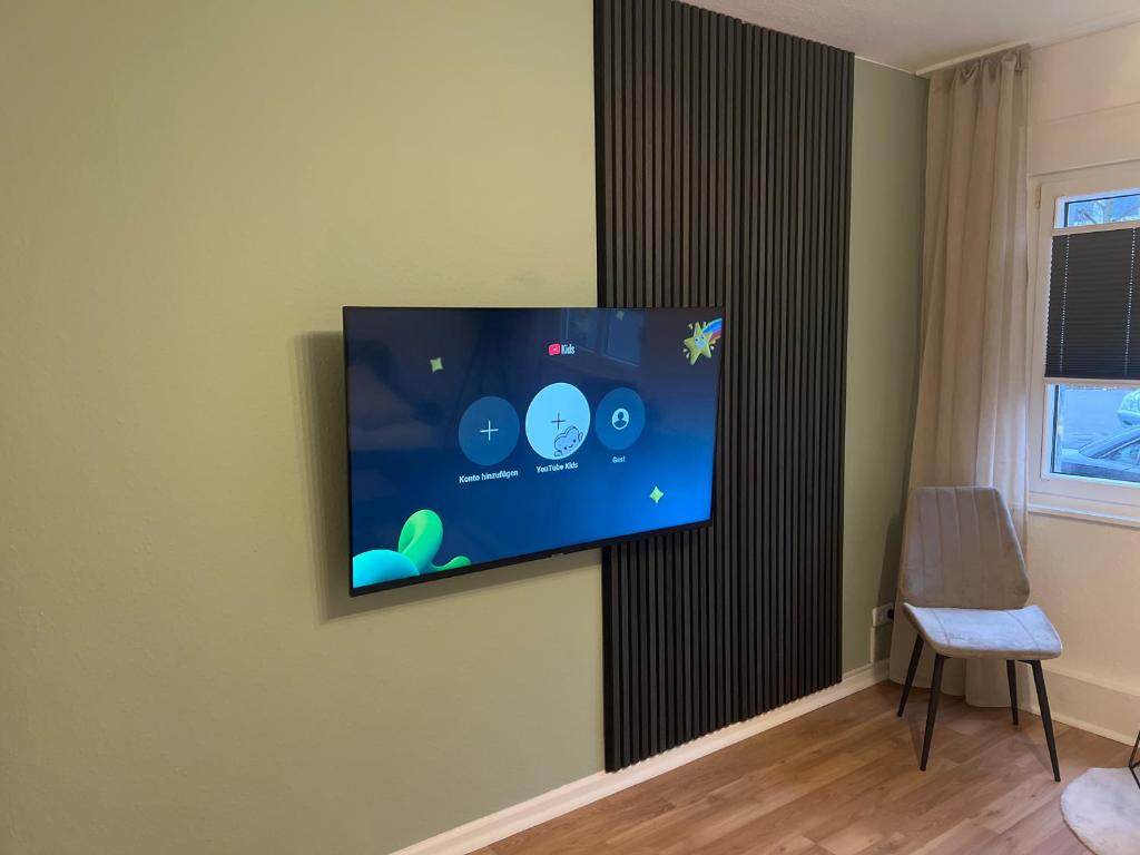 Un televisor de pantalla plana colgado en una pared en Apartment Paris, WIFI, CITY, en Krefeld