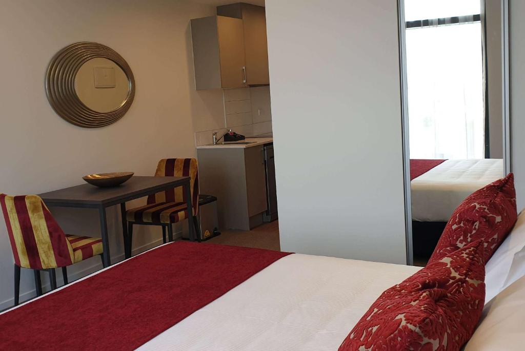 Postel nebo postele na pokoji v ubytování Ramada Suites by Wyndham Auckland Manukau Pacfic Centre