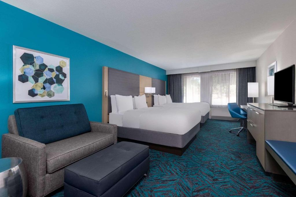 a large hotel room with a bed and a chair at Radisson Hotel Colorado Springs Airport in Colorado Springs