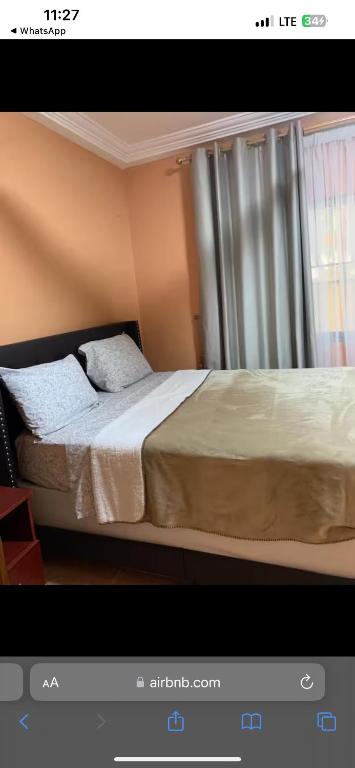 una camera da letto con un letto grande con una finestra di Inventi Lodge a Accra