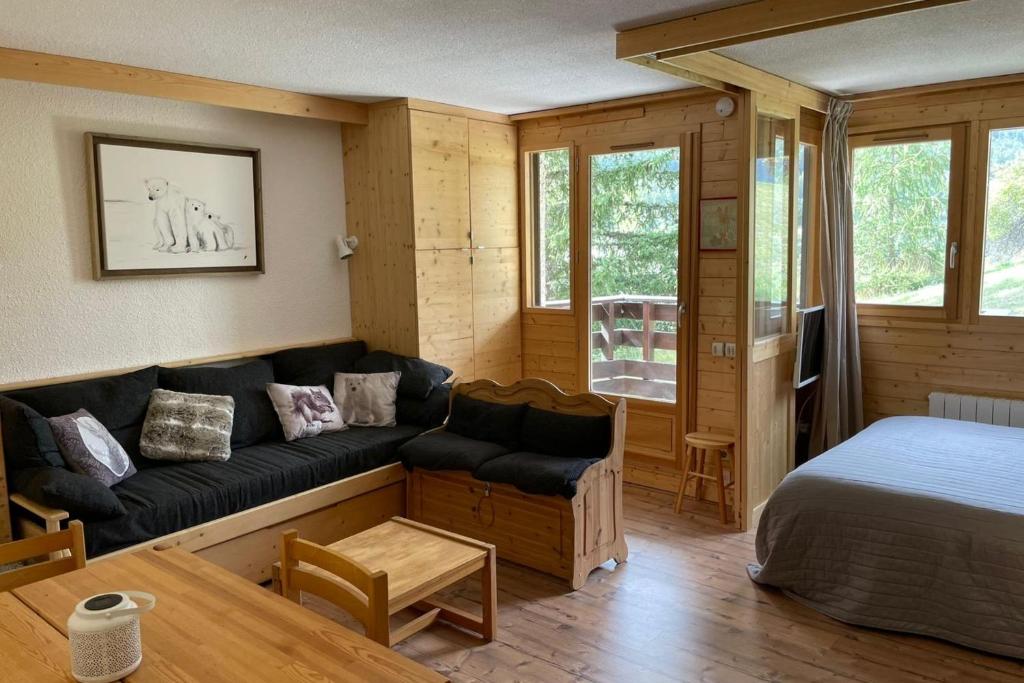 un salon avec un canapé et un lit dans l'établissement Pretty T2 with balcony and view to the slopes, à Saint-Chaffrey