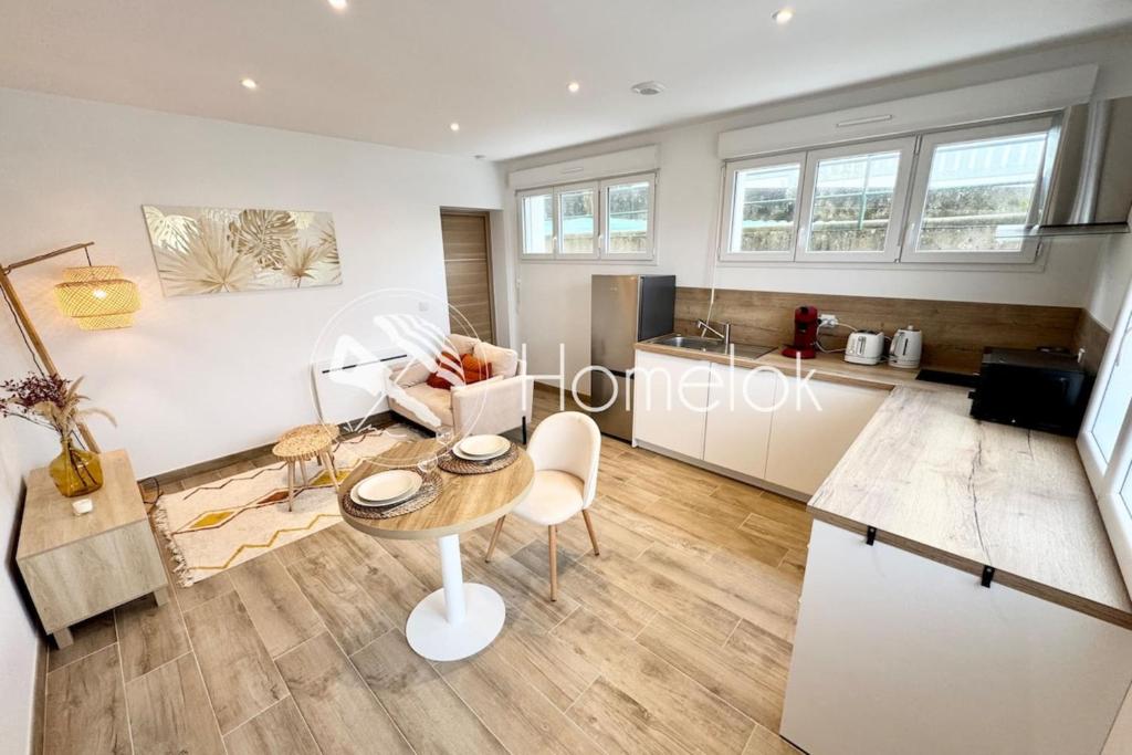 a living room with a table and a kitchen at Lovely ! T2 neuf archi cosy 1 in Quimperlé