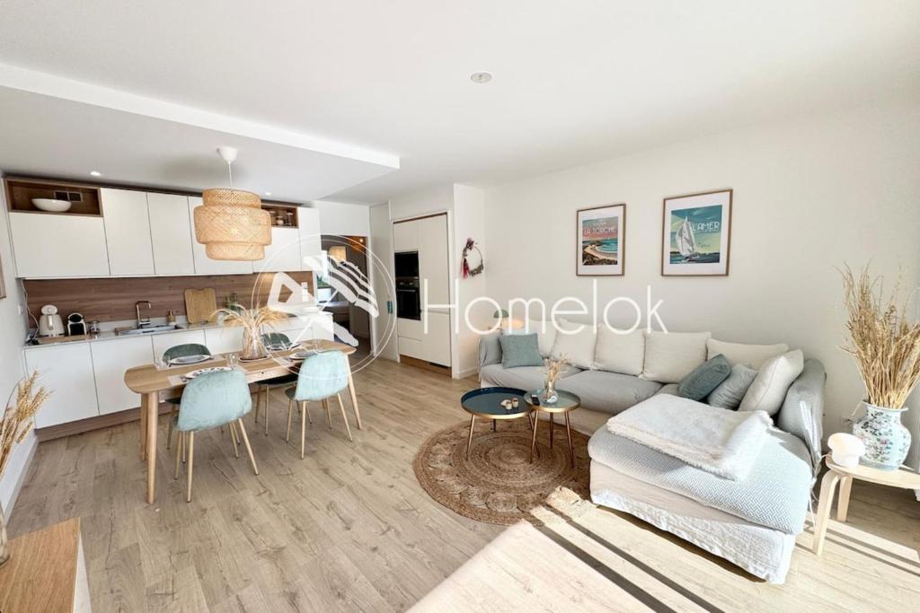 una sala de estar con un sofá y una mesa en Lovely ! T3 de standing - Proche bourg et plages, en Ploemeur