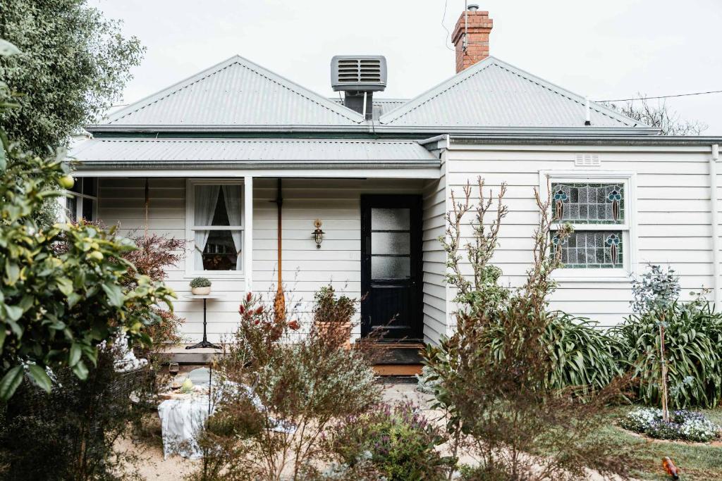 a white house with a black door at Benambra Cottage c1860 in Queenscliff