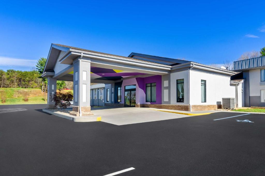 a large white and purple building with a parking lot at Spark by Hilton Daleville Roanoke North in Daleville