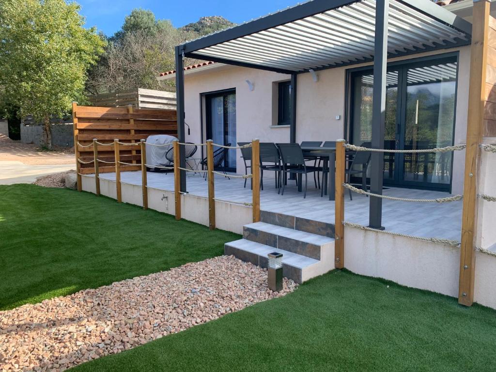 une maison avec un patio avec une table et des chaises dans l'établissement Villa SOLEIL, à Figari