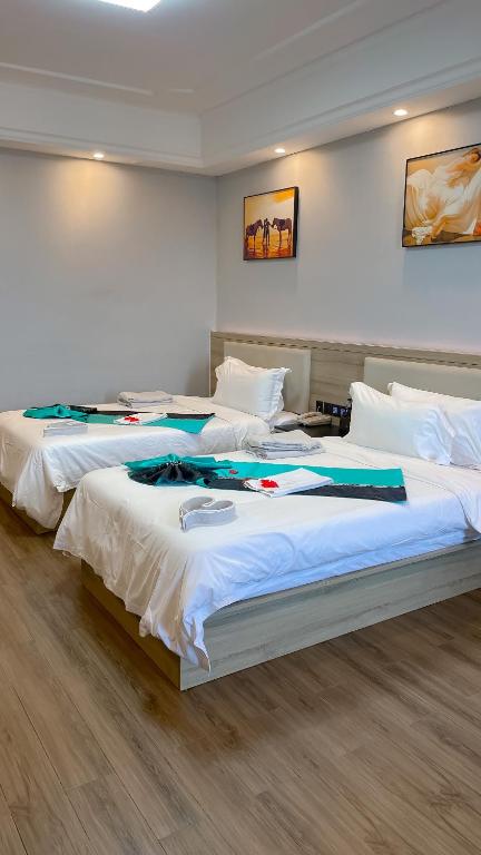 two beds in a hotel room with at G.C ROYAL HOTEL in Accra