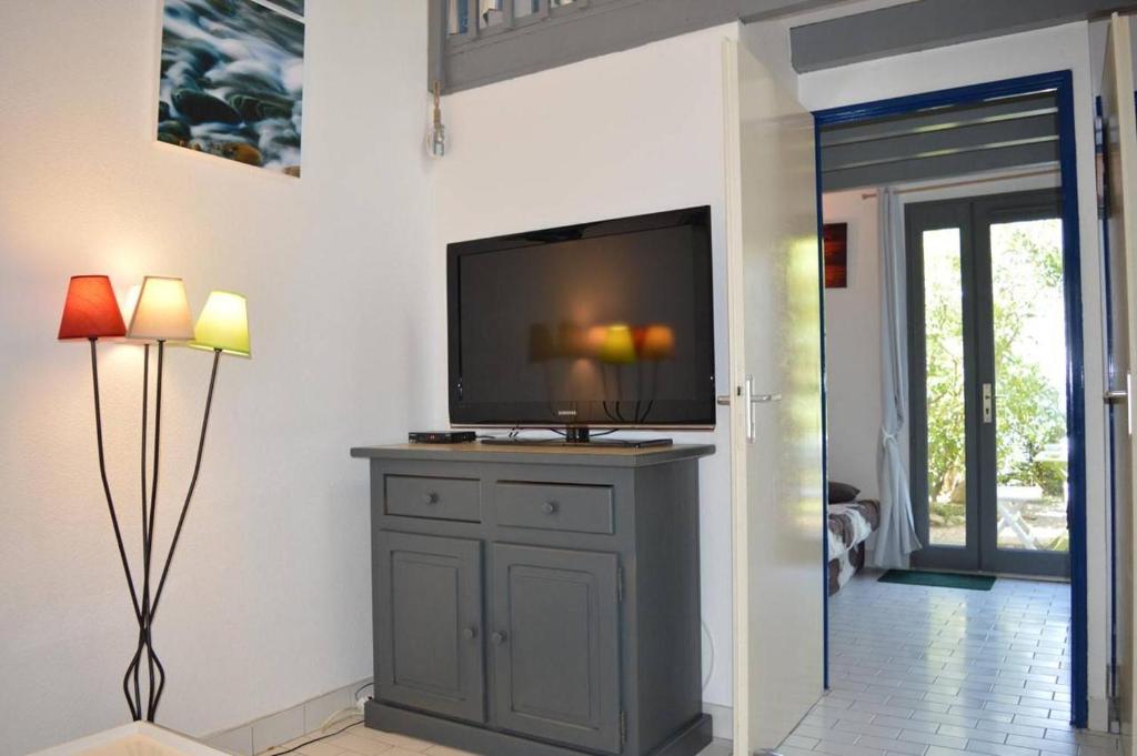 un salon avec une télévision à écran plat sur une armoire dans l'établissement Maison 2 pièces mezzanine 6 couchages SAINT CYPRIEN SC890-028, à Saint Cyprien Plage