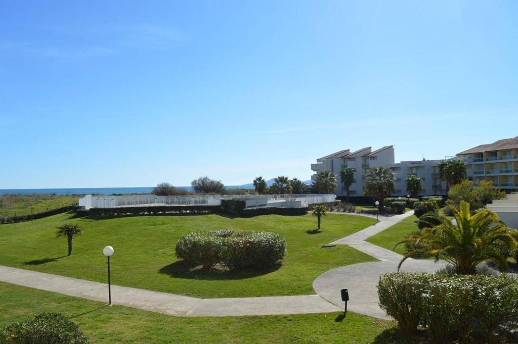 un parc avec un bâtiment et une passerelle dans l'établissement Appartement 2 pièces 4 couchages SAINT CYPRIEN SC050-037D, à Saint Cyprien Plage