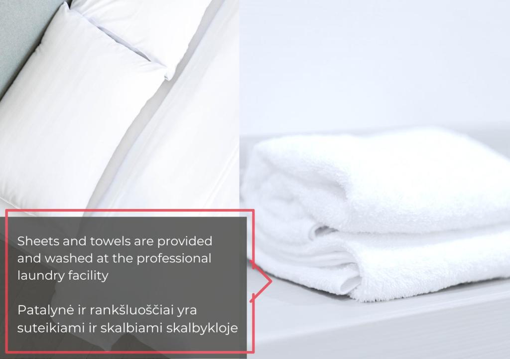 stos ręczników leżący na łóżku w obiekcie cohost I New Bastėja Life Apartments w-Garage Prkg & Self Check-in w Wilnie