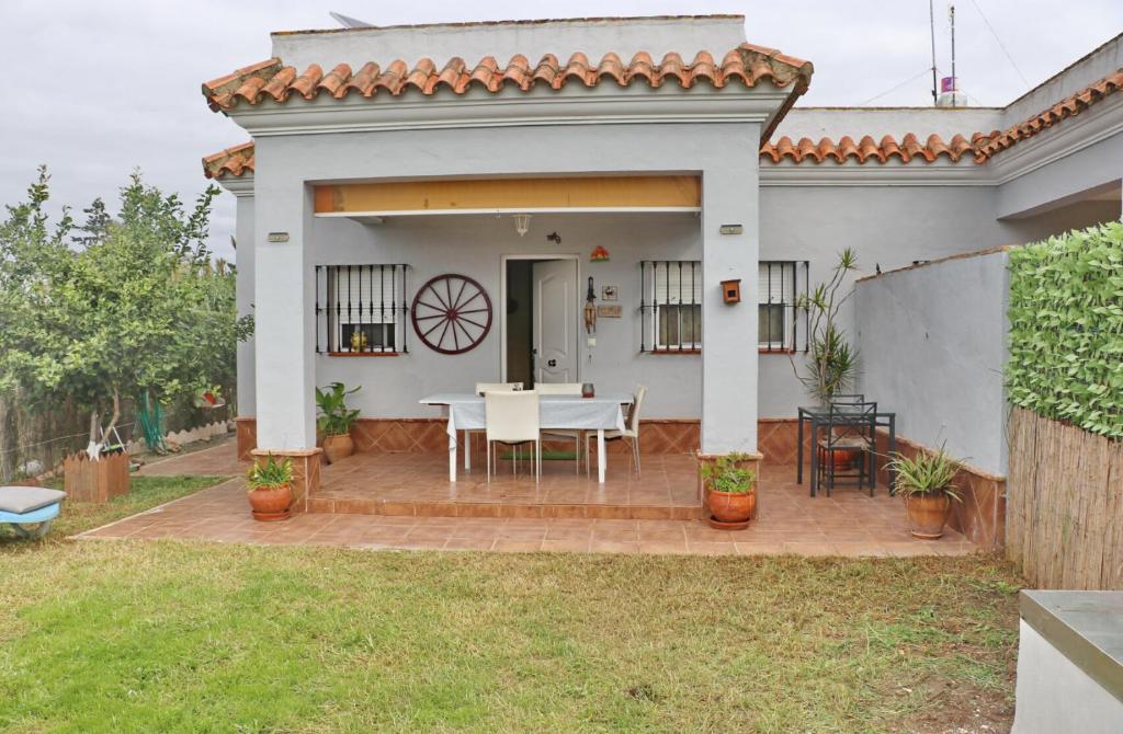 a house with a patio with a table and chairs at Casa familiar Palmar in El Palmar