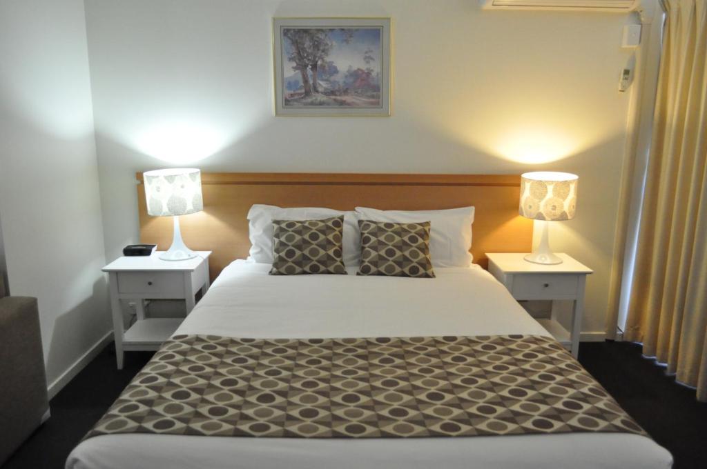 a bedroom with a large bed with two night stands at Albury Burvale Motor Inn in Albury