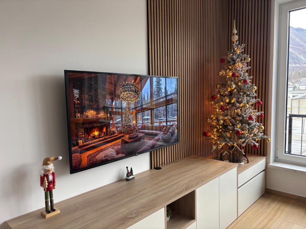 un salon avec un sapin de Noël et une télévision dans l'établissement Charming Bovec Apartment, à Bovec