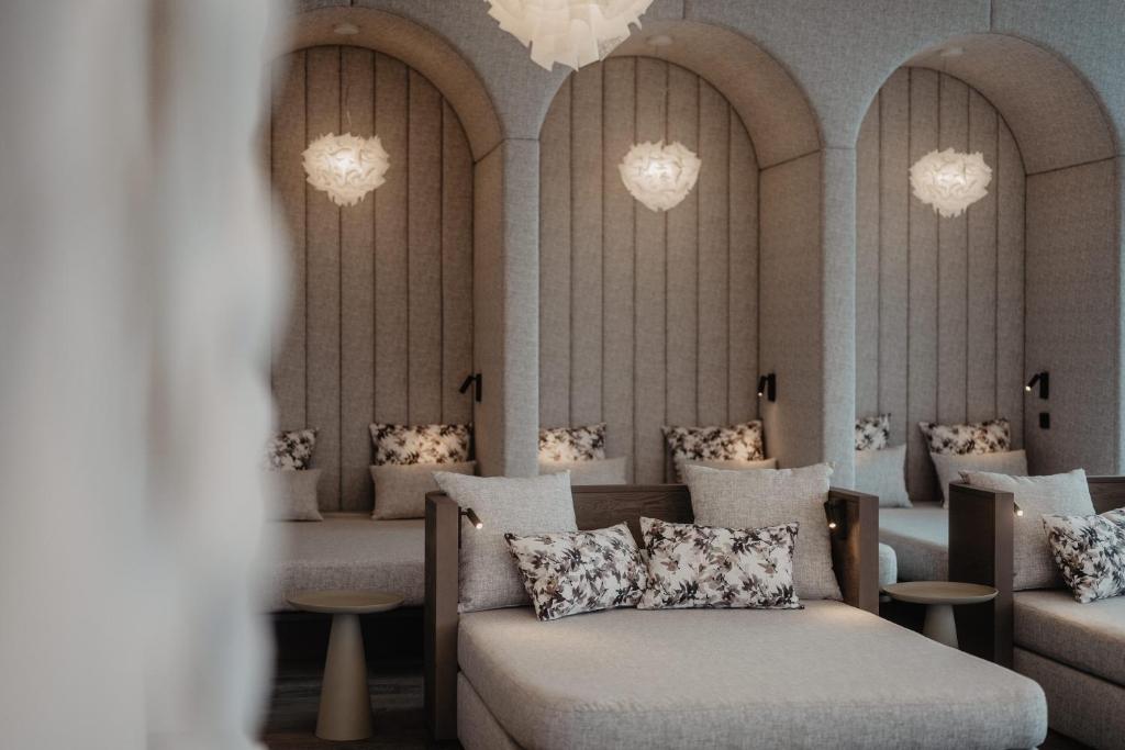 a waiting room with couches and chairs and chandeliers at Hotel Berghof - St Johann in Salzburg in Sankt Johann im Pongau
