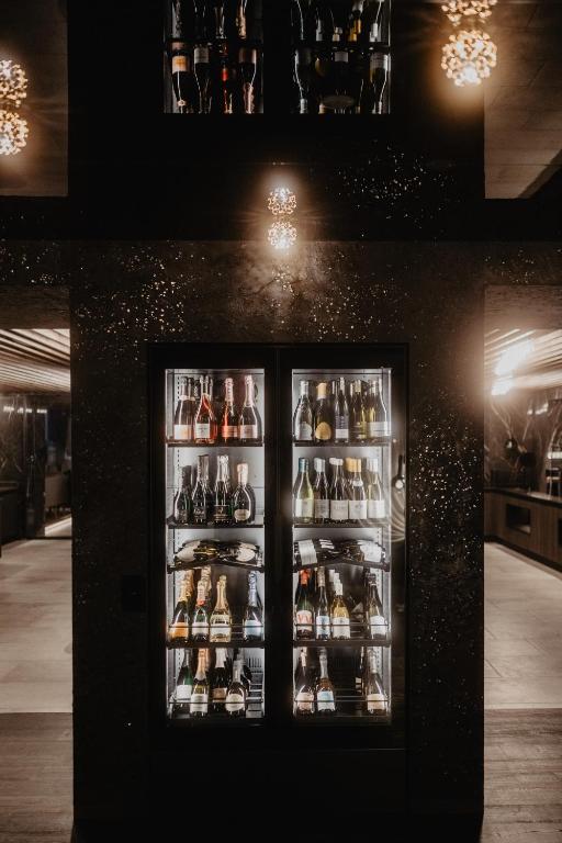 a refrigerator filled with lots of bottles of alcohol at Hotel Berghof - St Johann in Salzburg in Sankt Johann im Pongau