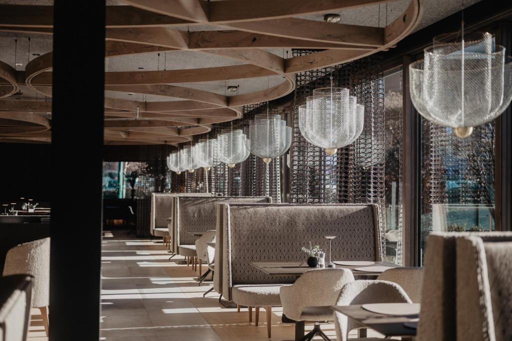 a dining room with tables and chairs and chandeliers at Hotel Berghof - St Johann in Salzburg in Sankt Johann im Pongau