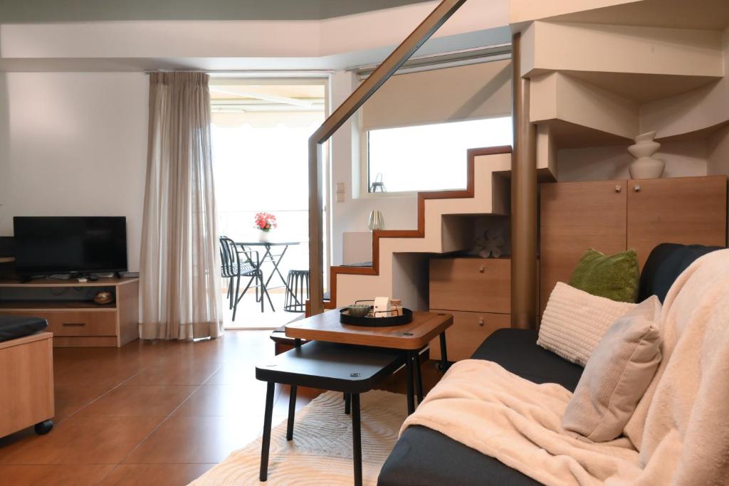 a living room with a couch and a staircase at Dione Central Loft in Heraklio Town