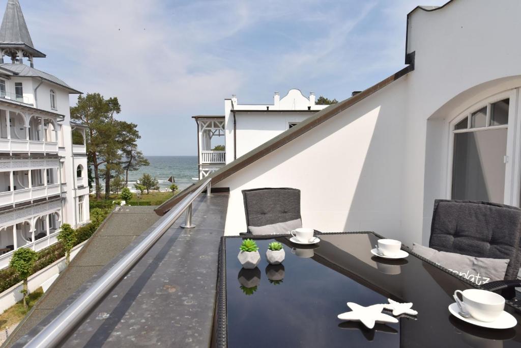 un balcone con tavolo e sedie e l'oceano di Ferienwohnung Strandnest in der Villa Gudrun Binz a Binz