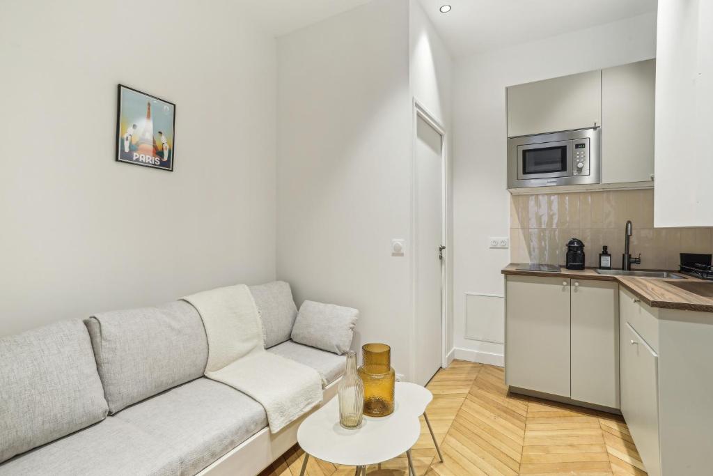 a white living room with a couch and a table at Lavie Maison Hot Tub and AC Near Arc de Triomphe in Paris