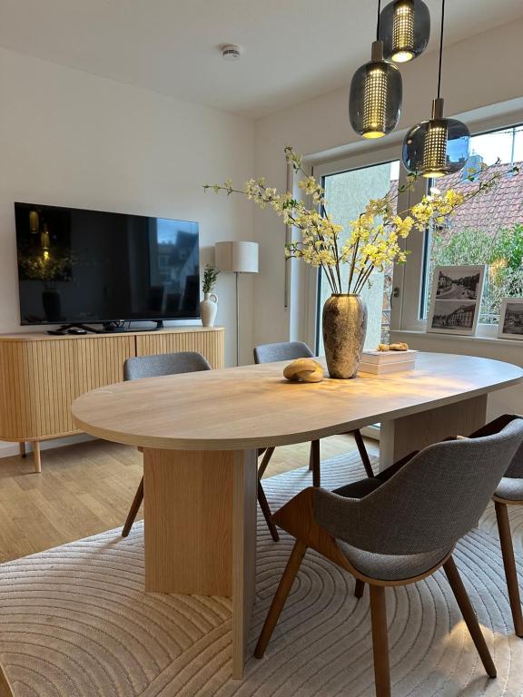 a dining room with a wooden table and chairs at Deluxe-Family Apartment mit Terrasse, Küche & Parkplatz in Offenburg