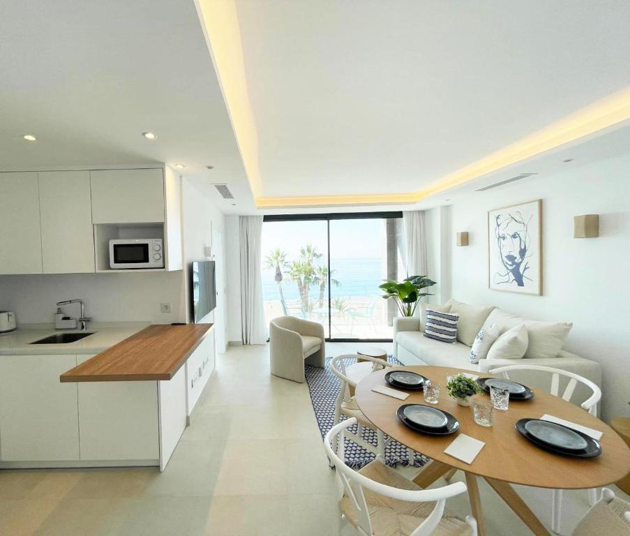 a kitchen and living room with a table and a couch at Apartamento LaViu 2B by Croma in Estepona