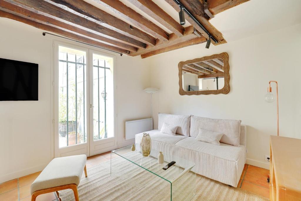 - un salon avec un canapé blanc et un miroir dans l'établissement Maison à Saint-Germain-des-Prés, à Paris