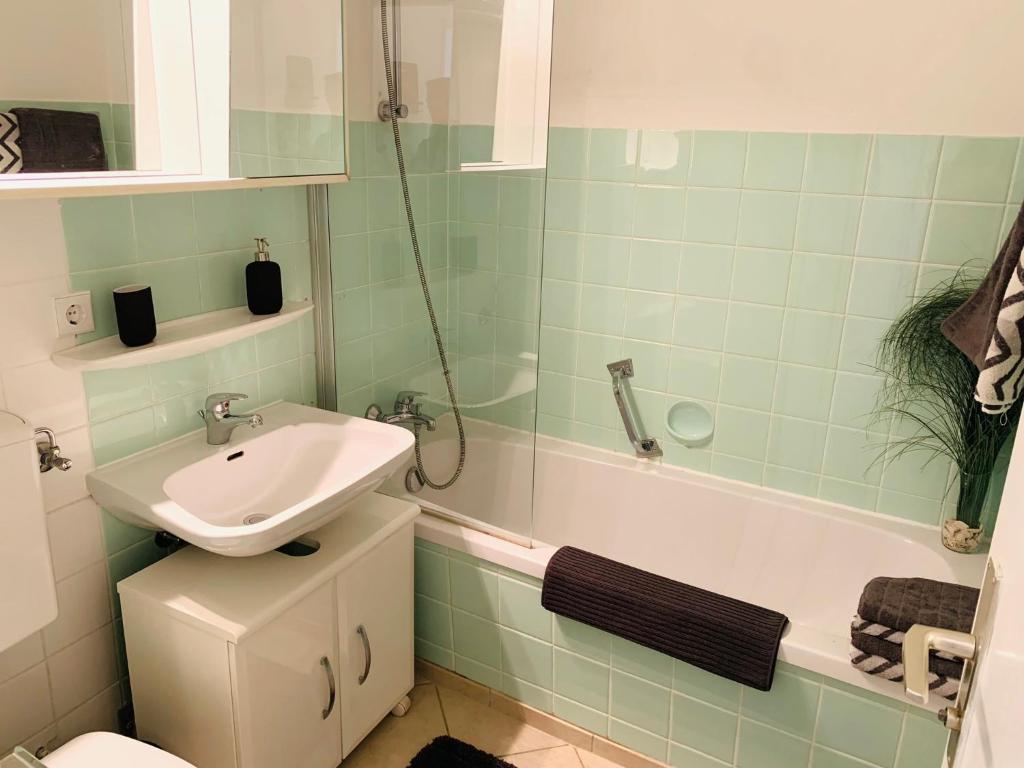 a bathroom with a sink and a toilet and a tub at Apartment Panoramablick in Bad Mergentheim