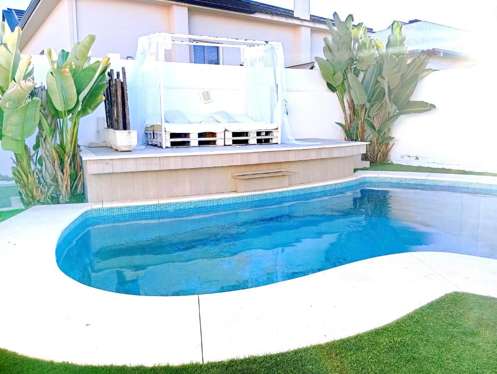 een zwembad in de achtertuin van een huis bij Chalets en Punta Umbría in Punta Umbría