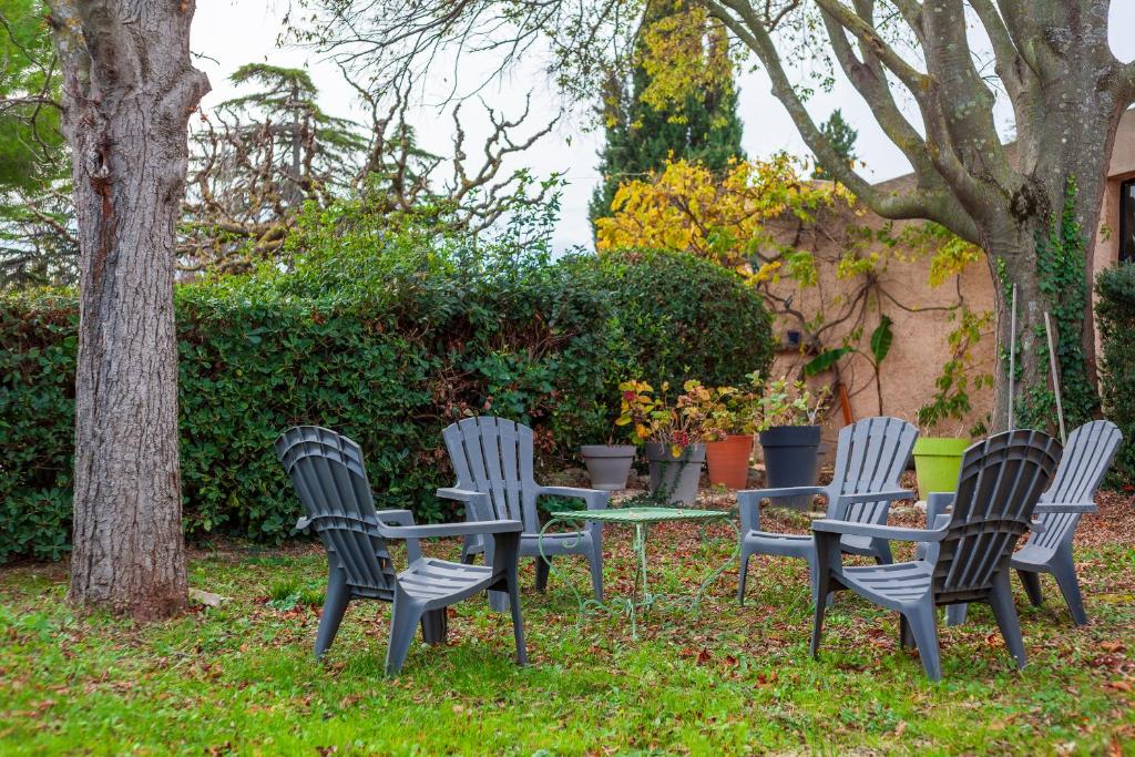 un groupe de chaises et une table dans l'herbe dans l'établissement Lou Jas - Cassis, à Cassis