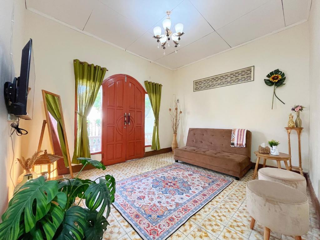 a living room with a couch and a red door at Bohaus in Alastuwo