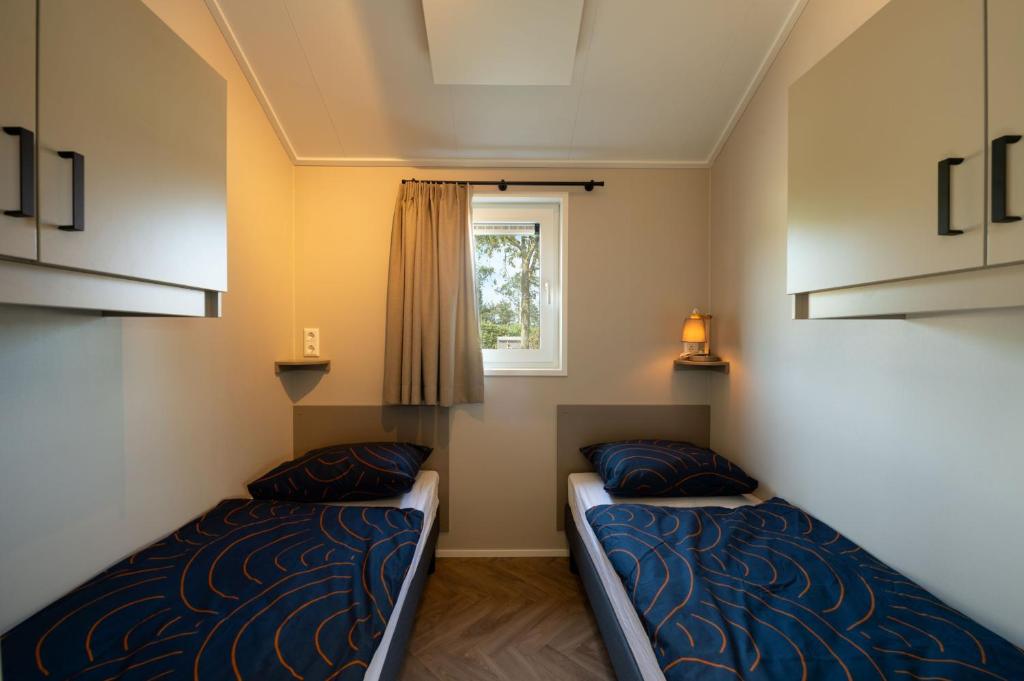 Postel nebo postele na pokoji v ubytování Vakantiepark duinzicht