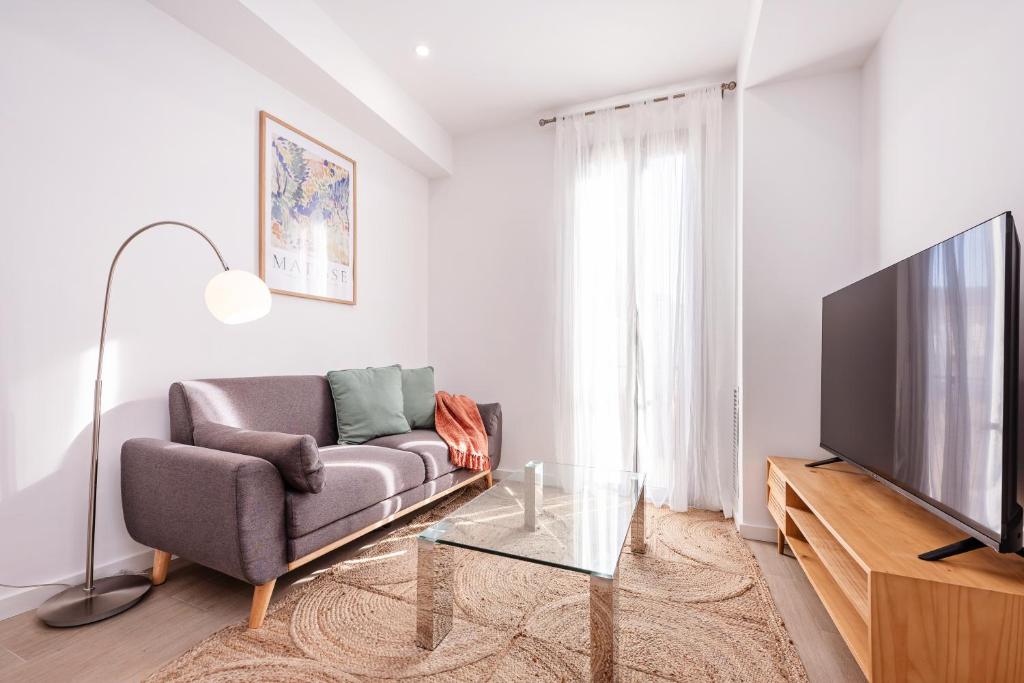 ein Wohnzimmer mit Sofa und Flachbildfernseher in der Unterkunft Sweett - Harmony Central in Barcelona