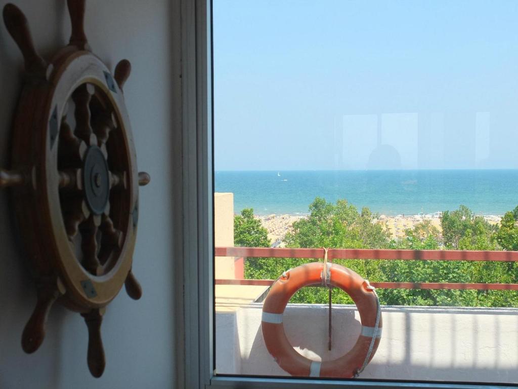 a window with a life preserver on a balcony with the ocean at Hotel Dell'Angelo in Rimini