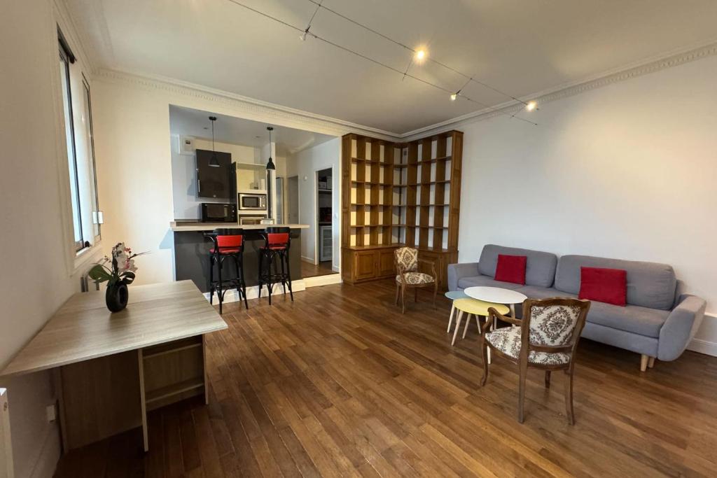 un salon avec un canapé et une table dans l'établissement Charming apartment in the center of Caen, à Caen