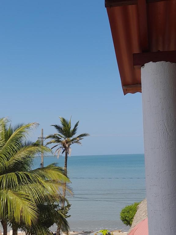 a view of a beach with palm trees and the ocean at Cabaña frente al mar de San Antero in San Antero
