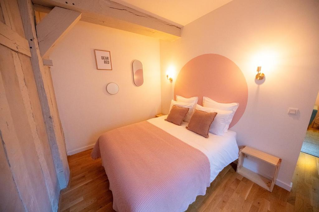 a bedroom with a white bed with a largeorthole at Rosalie - Bienvenue dans le cœur historique de Troyes in Troyes
