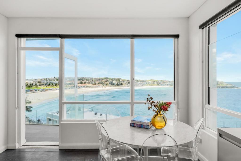 a dining room with a table and a view of the ocean at Breathtaking Bondi Beach in Sydney