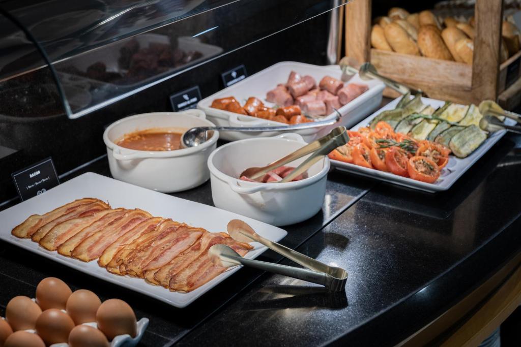 a buffet of food with meat and eggs on a counter at Hotel del Mar in Barcelona