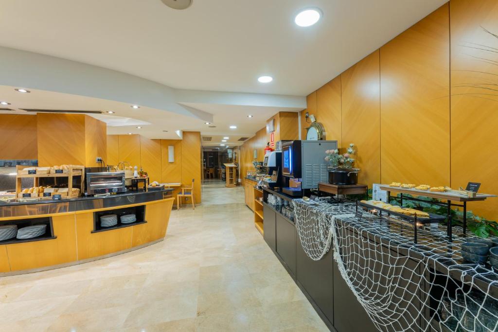 a restaurant with a counter with food on it at Hotel del Mar in Barcelona