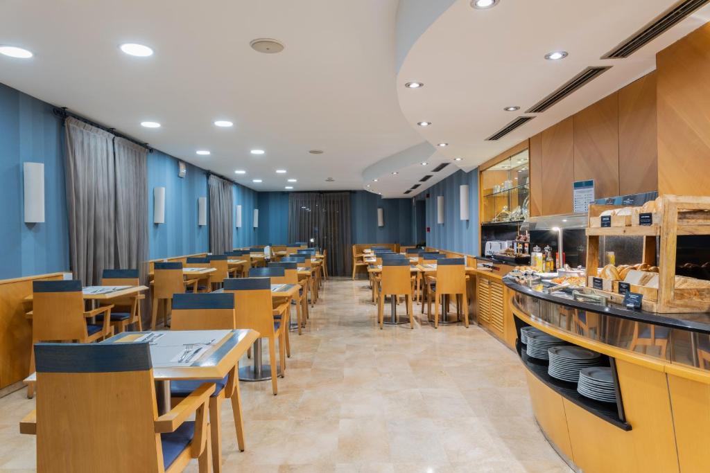 a restaurant with blue walls and wooden tables and chairs at Hotel del Mar in Barcelona