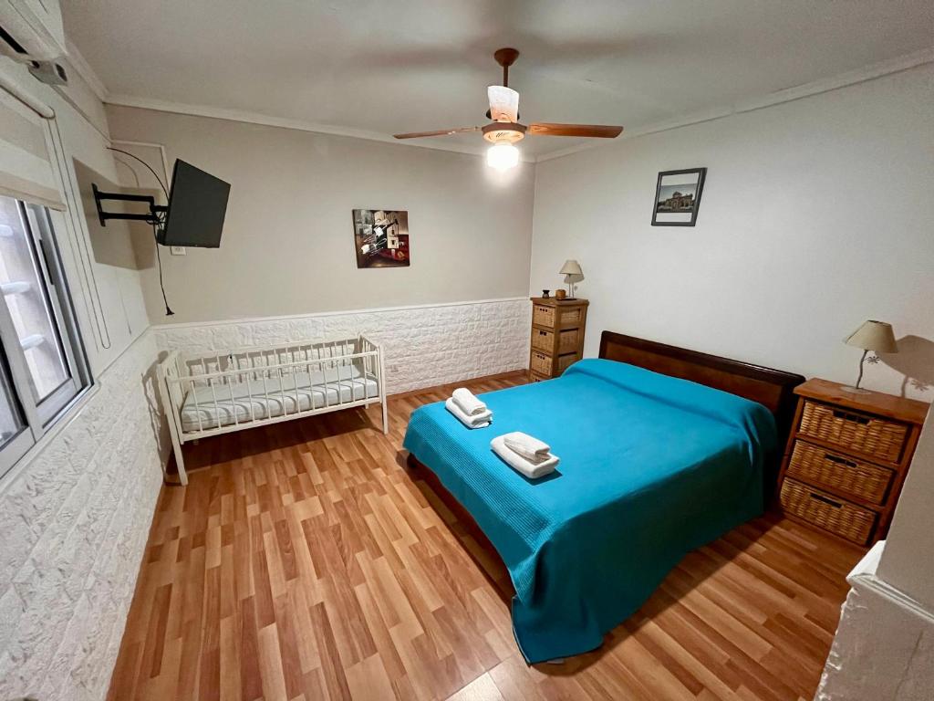 una camera da letto con un letto blu e una TV a schermo piatto di Quinta a metros del Parque Municipal y La Antigua Pulpería a Mercedes