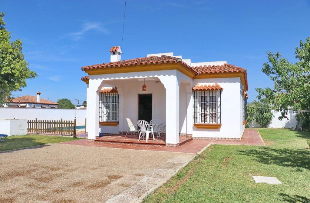 a small white house with a porch and two chairs at Casa Ana in Conil de la Frontera