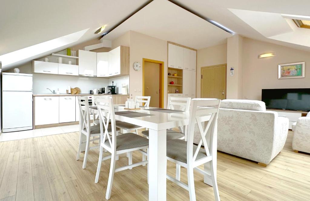 a kitchen and living room with a white table and chairs at Old City Views - Luxury 2BDR Apt & Free Parking in Sofia