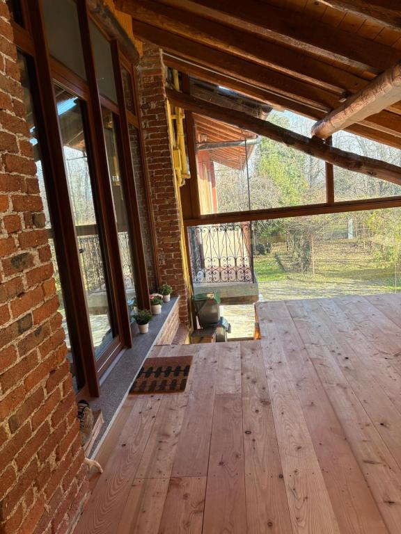 pusty pokój z drewnianą podłogą i oknami w obiekcie casa margherita w mieście Borgo San Dalmazzo
