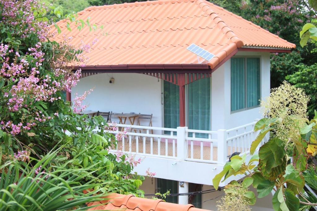 Casa blanca con techo naranja y balcón en ชรัส รีสอร์ท เกาะล้าน, en Ko Sak