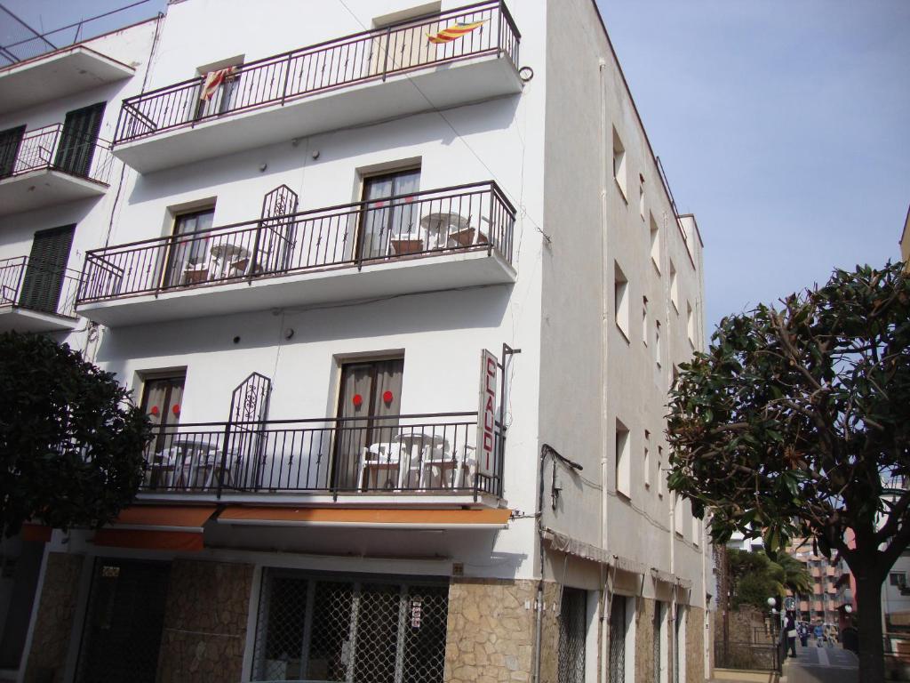 un edificio blanco con balcones en un lateral en Apartaments Claudi, en Tossa de Mar
