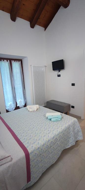 sypialnia z łóżkiem z telewizorem na ścianie w obiekcie casa margherita w mieście Borgo San Dalmazzo